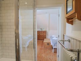 A bathroom with a shower and a view into an adjacent bedroom at The Little Rose in Lyme Regis