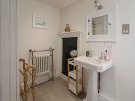 A bathroom with a wash basin and a radiator at The Little Rose in Lyme Regis