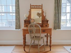 A vanity table with a mirror and a chair at The Little Rose in Lyme Regis