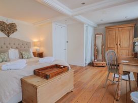 A bedroom with a bed and wooden furniture at The Little Rose in Lyme Regis