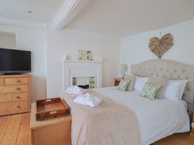A bedroom with a bed and television at The Little Rose in Lyme Regis