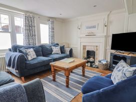A living room with a sofa and television at The Little Rose in Lyme Regis