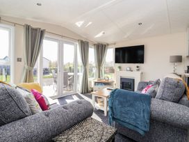 A living room with a television and a sliding door at Away Daze in Carnaby near Bridlington