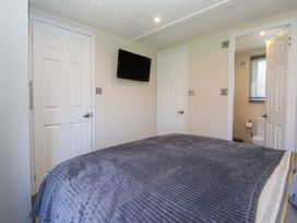 A bedroom with a bed and a television at Away Daze in Carnaby near Bridlington