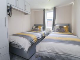 A bedroom with two single beds and a television at Away Daze in Carnaby near Bridlington