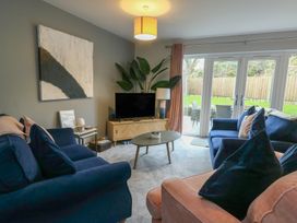 A living room with a television and sliding doors at 11 Parc Delfryn near Benllech