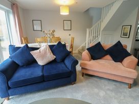 A living room with a blue sofa and a pink armchair at 11 Parc Delfryn Brynteg near Benllech