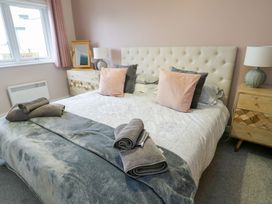 A bedroom with a bed and bedside table at 11 Parc Delfryn in Brynteg near Benllech