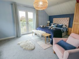 A bedroom with a bed and sliding doors at 11 Parc Delfryn in Brynteg near Benllech