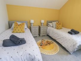 A bedroom with two beds and a tiger rug at 11 Parc Delfryn in Brynteg near Benllech