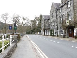 A street view with a stone building labeled Royal Oak Hotel and a sidewalk with railings at Mews Cottage in Llanrwst
