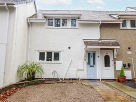A house facade with potted plant and gravel pathway at Green Cottage Borth-Y-Gest