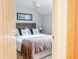 A bedroom with a bed and framed picture at Green Cottage in Borth-Y-Gest