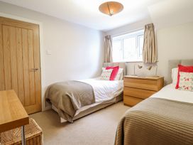 A bedroom with two single beds and a dresser at Green Cottage in Borth-Y-Gest
