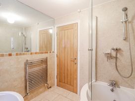 A bathroom with a shower and bathtub at Green Cottage in Borth-Y-Gest