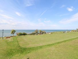 A grassy lawn area with people walking and the sea in the background at Flat 1 in Hunstanton