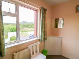 A bedroom with a window and chair at Forest View in Ballinskelligs, County Kerry