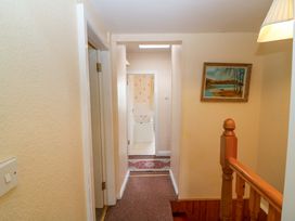 A hallway with a staircase and a bathroom entrance at Forest View, Ballinskelligs, County Kerry