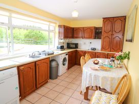 A kitchen with wooden cabinets and a table set for breakfast at Forest View Ballinskelligs County Kerry