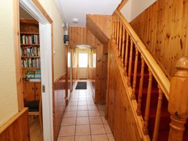 A hallway with a staircase and bookcase at Forest View in Ballinskelligs, County Kerry
