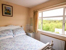 A bedroom with a bed and window at Forest View in Ballinskelligs, County Kerry
