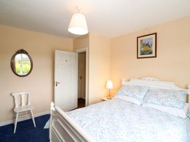 A bedroom with a bed and chair at Forest View in Ballinskelligs, County Kerry