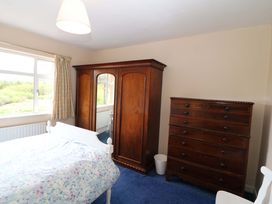 A bedroom with a bed and wooden furniture at Forest View in Ballinskelligs, County Kerry