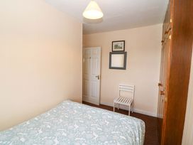 A bedroom with a bed and a chair at Forest View, Ballinskelligs, County Kerry