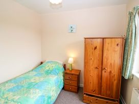 A bedroom with a bed, wardrobe, and lamp at Forest View in Ballinskelligs, County Kerry