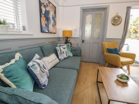 A living room with a sofa, armchair, and coffee table at 4 Haven Villas in Conwy