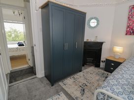 A bedroom with a wardrobe, bed, and nightstand at 4 Haven Villas in Conwy