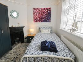 A bedroom with a bed and nightstand at 4 Haven Villas in Conwy