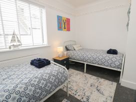 A bedroom with two beds and a nightstand at 4 Haven Villas in Conwy