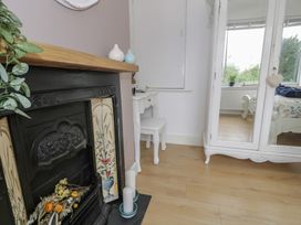 A room with a fireplace and a desk at 4 Haven Villas in Conwy