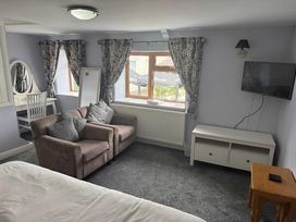 A bedroom with a sofa and a desk at Triangle Inn Coachouse Rhayader