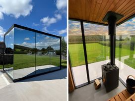 A modern outdoor area with glass walls and a stove at High Longlands in Cartmel