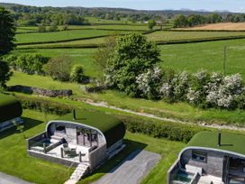 Two cabins with grass roofs and a deck at High Longlands in Cartmel