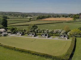 A view of huts in a green field at Little Heaning in Cartmel