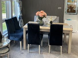 A dining room with a table and chairs at Loluke Lodge on The Lake, 5 Coniston Drive, Borwick near Carnforth