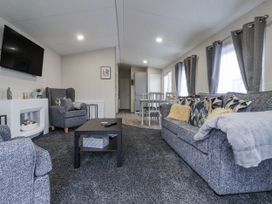 A living room with sofa and armchair at Lazy Daze in Carnaby near Bridlington