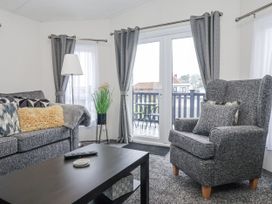 A living room with a sofa and armchair at Lazy Daze in Carnaby near Bridlington