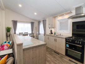 A kitchen with a kitchen counter and dining table at Brighter Daze Carnaby near Bridlington