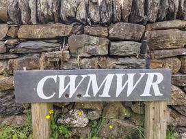 A slate sign with the text CWMWR in front of a stone wall at Cwmwr Penybontfawr