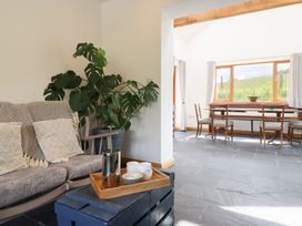 A living room with a sofa and dining area at Cwmwr Penybontfawr