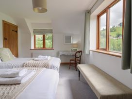 A bedroom with two beds and a table at Cwmwr in Penybontfawr