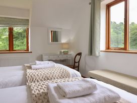 A bedroom with twin beds and a vanity table at Cwmwr in Penybontfawr