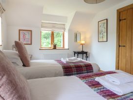 A bedroom with two beds and a window at Cwmwr in Penybontfawr