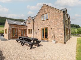 An outdoor area with a brick house and table at Cwmwr Penybontfawr