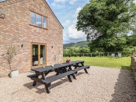 An outdoor area with a table and seating at Cwmwr in Penybontfawr