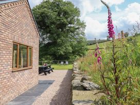 An outdoor area with a garden and seating at Cwmwr in Penybontfawr